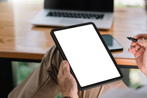 Vista de cerca del hombre usando la pantalla blanca en blanco de la tableta para mensajes de texto o información. photo