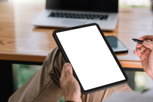 Close up view of man using tablet blank white screen for text message or information. stock photo