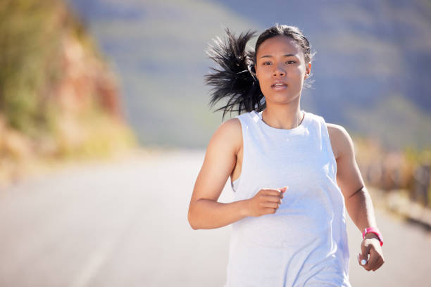 istock Active mixed race young woman running for exercise outdoors. Athlete jogging for a refreshing cardio training workout in the morning. Determined to build endurance to reach fitness and wellness goals 1400645421