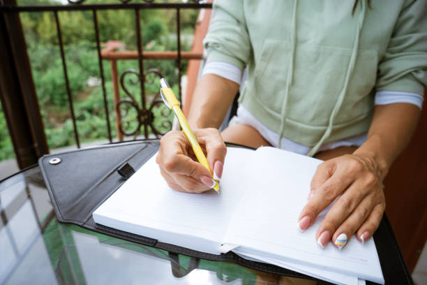 istock woman writes in a notebook at a table on the terrace 1400648283