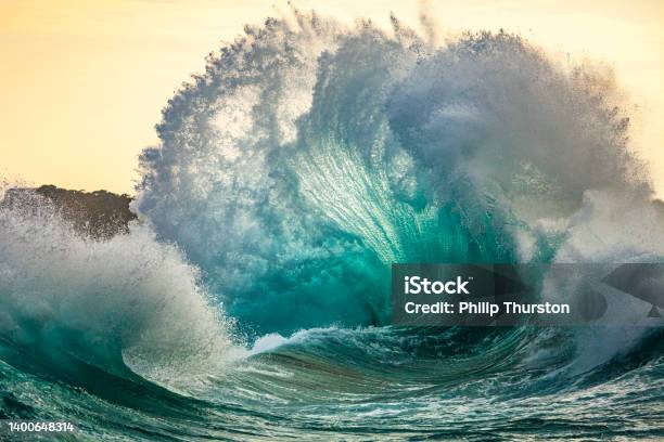 Powerful Storm Generated Ocean Swell Exploding Dangerously On The Shoreline With Soft Golden Sky Stock Photo - Download Image Now