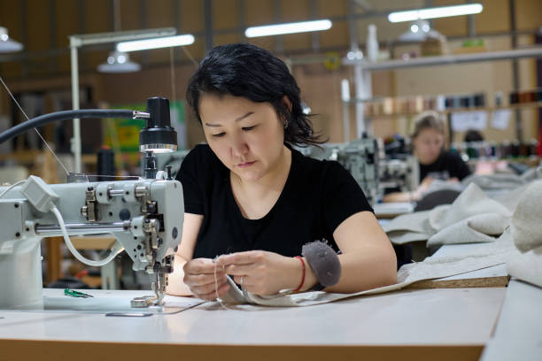 costurera o trabajadora en fábrica textil asiática cosiendo con máquina de coser - textile industry textile wool textile factory fotografías e imágenes de stock