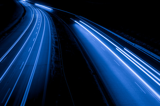 A highway at night with light trails in motion from traffic