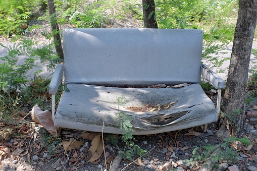 Broken chairs are left neglected in unkempt yards.