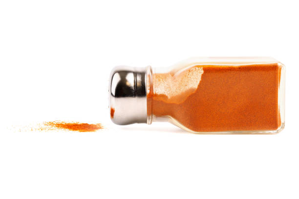 This is a close up of the hand of a woman shopping at the Saturday Farmer’s Market holding up a spice jar.