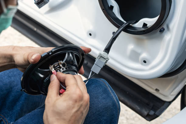 istock Mechanic man installing speaker on vehicle door part in garage 1400652892