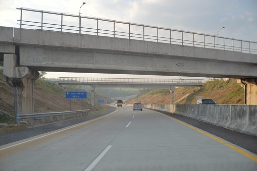 Semarang, Indonesia, Sept 18, 2020. An empty toll road with a pedestrian bridge construction for the public crossing it
