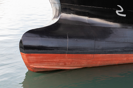 Industrial ship hull with bulbous bow. This is a protruding bulb at the bow of a ship reducing drag and thus increasing speed, range, fuel efficiency, and stability