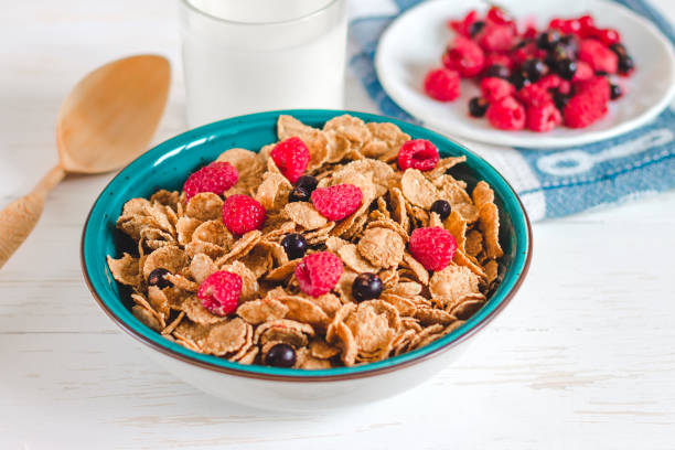 Breakfast cereal with milk on a white background. Flakes on a plate. Muesli with berries and milk Breakfast cereal with milk on a white background. Flakes on a plate. Muesli with berries and milk bran stock pictures, royalty-free photos & images