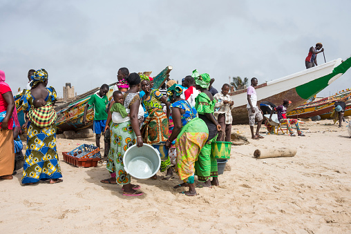 Tanji, The Gambia - May 08, 2017: Women waiting for the fish from the boats on the beach