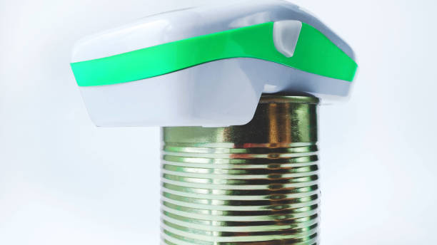 Electric can opener and canned goods on white background stock photo