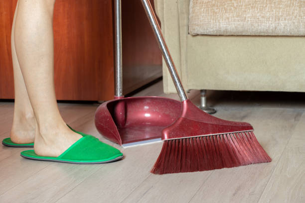 女の子は自宅でブラシで床を掃除し、床に足を乗せ、家を掃除し、清潔さ - broom sweeping cleaning work tool ストックフォトと画像