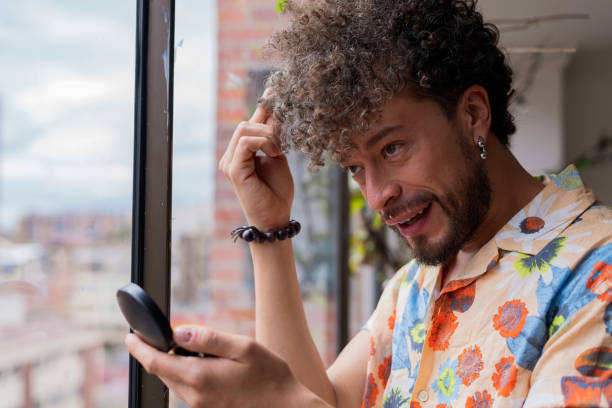 istock latino man is doing makeup on his face while being photographed 1400660464