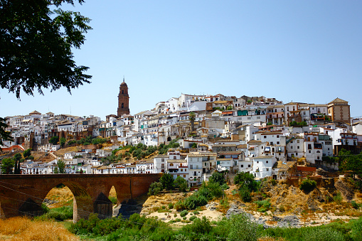 General view of Montoro, in Andalusi Spain,  on a sunny summer day with the medieval bridge in the foreground over the Guadalquivir river