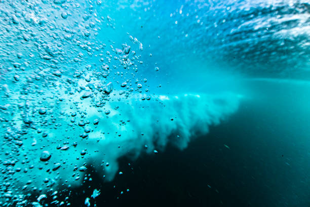 Macro close up of underwater bubbles created by a breaking wave in the ocean