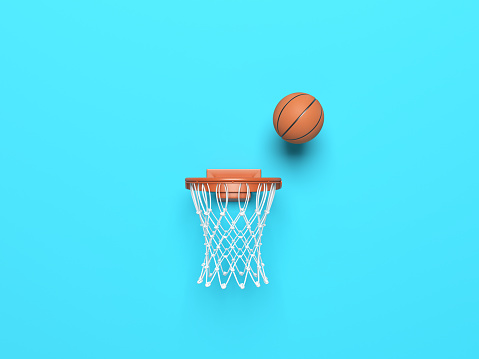 Basketball ball in the hoop on blue color background.