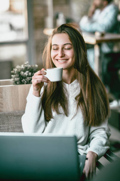 istock Female Closing Eyes And Relaxing With Coffee And Laptop 1400667384