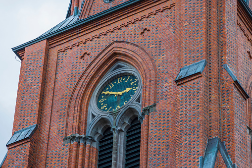 Beautiful view of top tower clock on famous Cathedral facade. Uppsala, Sweden, Europe.