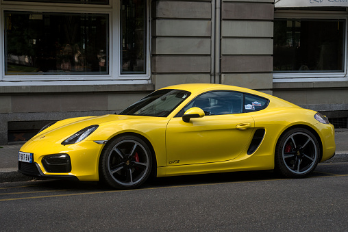 Mulhouse - France - 2 June 2022 - Profile view of Yellow porsche Cayman parked in the street