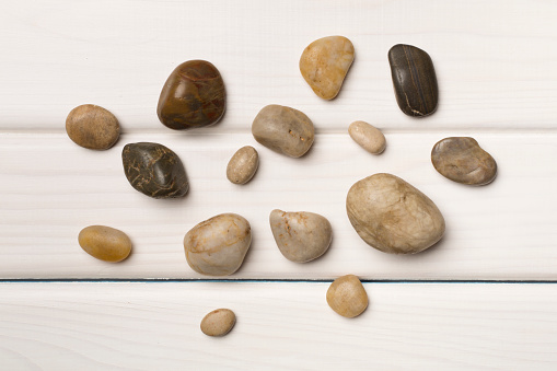 Set of sea stones on wooden background, top view.