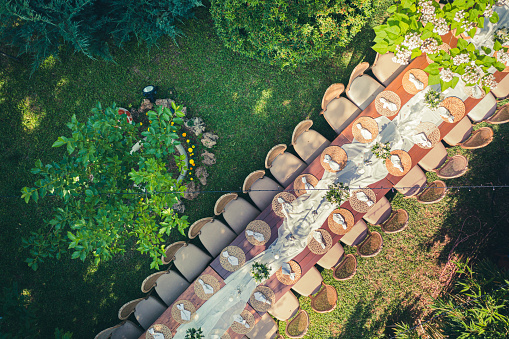 Big wedding dinner table in backyard view from above