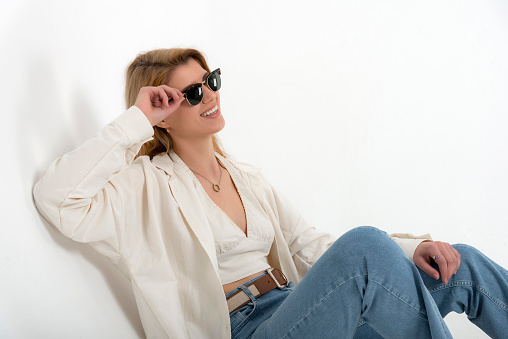 Blonde girl in photo shoot in studio with white background. Clothing shot for e-commerce. Clothing presentation.