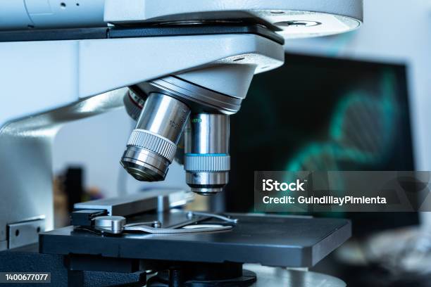Close Up Of The Lenses Of A Microscope With An Dna Image On The Background In The Computer Stock Photo - Download Image Now