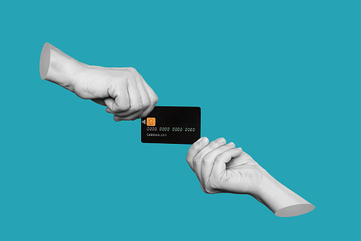 The black plastic credit card is in the hands of two women holding it from different sides isolated on a teal blue background. Trendy 3d collage in magazine style. Contemporary art. Modern design