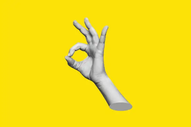 The female hand showing the ok gesture isolated on a yellow color background. Trendy abstact 3d collage in magazine urban style. Contemporary art. Modern design. Okay hand sign
