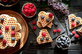 Waffles with berry fruit on wooden dark table