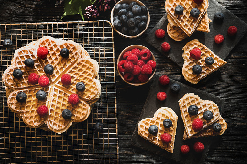 Heart shape Waffles with berry fruits on dark background