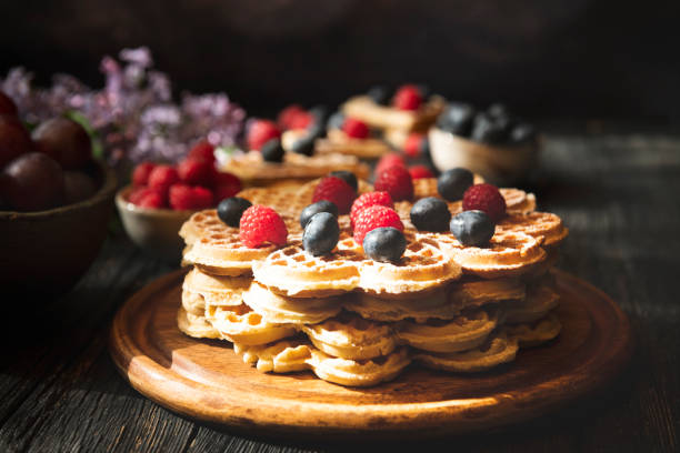 Heart shape Waffles with berry fruits on dark background