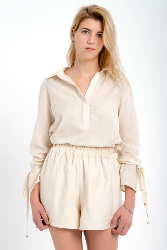 Blonde girl in photo shoot in studio with white background. Clothing shot for e-commerce. Clothing presentation.