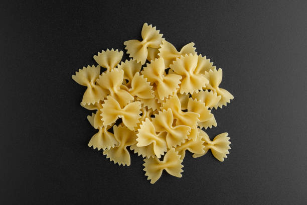 istock Raw pasta farfalle on black background. 1400686295