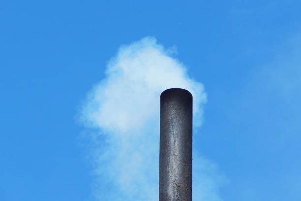 humo de la chimenea de una casa de pueblo, contra el cielo. - house farm brick chimney fotografías e imágenes de stock