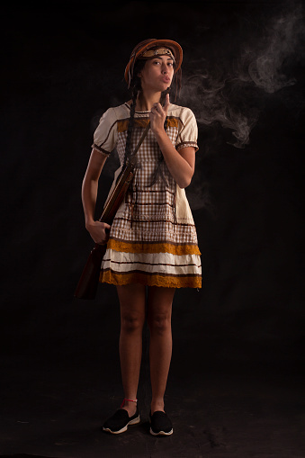 Young woman in a June party dress in a studio photo. Festa Junina