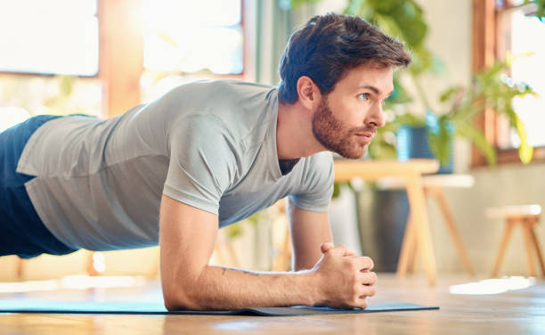 istock One fit young caucasian man doing elbow plank hold bodyweight exercise while training at home. Focused guy challenging himself to gain muscle, enhance upper body, core strength and increase endurance during workout 1400692538