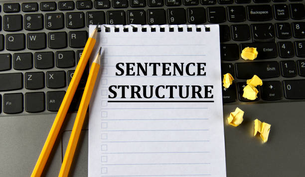 struttura della frase - parole in un blocco note bianco sullo sfondo di un laptop con matite - sentencing foto e immagini stock