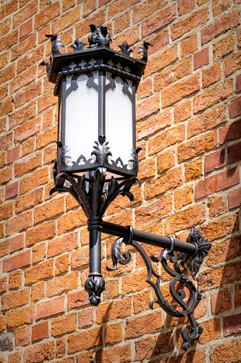 Beautiful old forged lantern on a brick wall