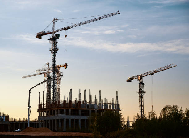 istock Silhouette of tower cranes and high-rise buildings under construction at a construction site at sunset 1400698547