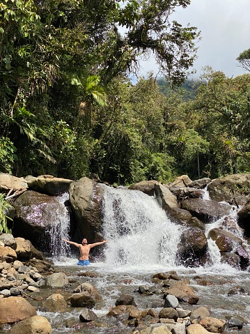 A young backpacker tourist male enjoying and relaxing while taking a bath over a waterfall in Papallacta, Napo Province, Ecuador.\n\nPapallacta, also called the “Gateway to the East” because the Ecuadorian Amazon region begins there, the tourist city of Papallacta has springs of ferruginous hot springs. Papallacta is just one hour from Quito, Pichincha.