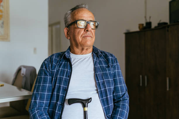 istock Senior man sitting with cane 1400702614