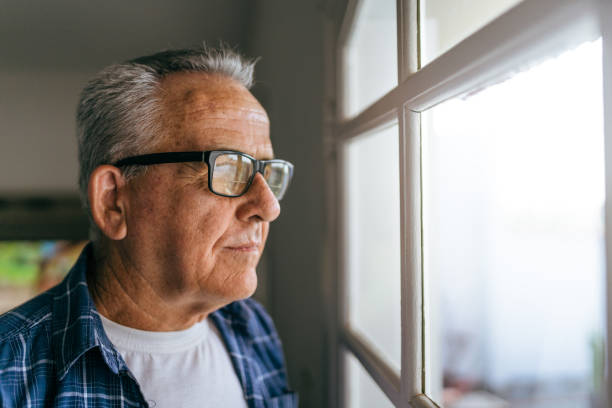 istock Senior man looking out the window 1400702615
