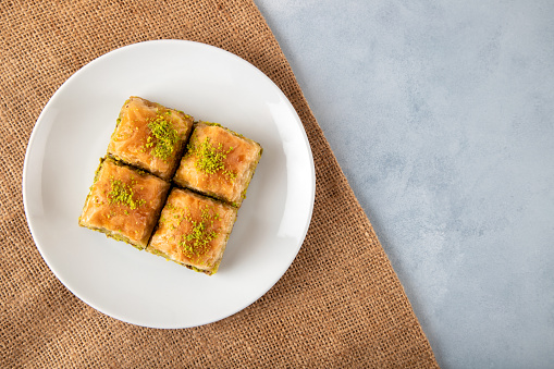 Pistachio baklava on a white plate.Traditional baklava directly above