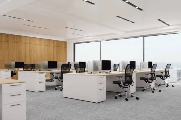 Interior of a modern office space with chairs, desks and computers.