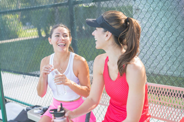 istock Female players laughing while having a break at tennis court 1400707708