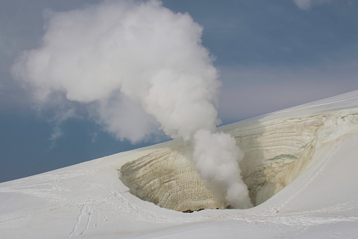 White steam coming from a sulphur stained fumarole on Mt. Asahi, Daizestuzan National Park, Hokkaido, Japan in winter