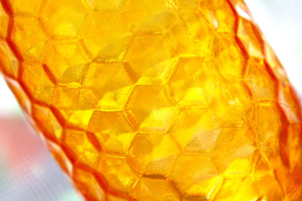 Abstract - Amber colored glass mason jar closeup - held up to the sun - looks like honeycomb pattern