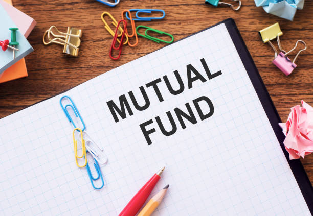istock Notebook with text Mutual Fund on a table with sticks, colored paper clips and wrinkled sheets. Personal finance conceptual 1400713103