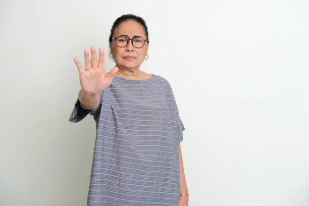 istock Elderly Asian women showing stop hand sign with serious face expression 1400719512